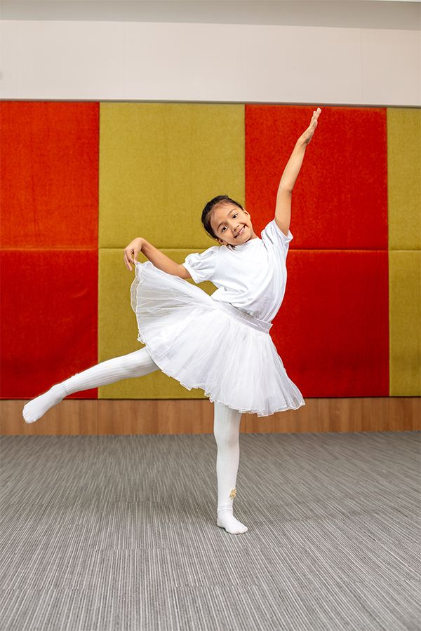 A young student at Imperial World School performing ballet in a white tutu, highlighting the school's dance programs.