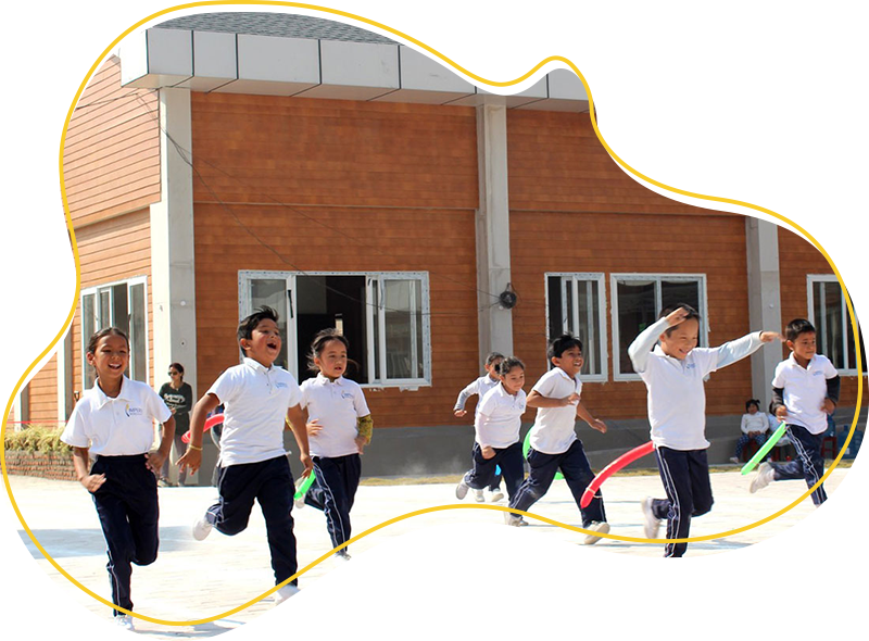 Imperial World School students running outside the school building, highlighting active and inclusive learning environment.