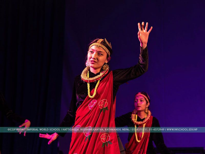 A student at Imperial World School performing a cultural dance on stage, dressed in traditional attire.