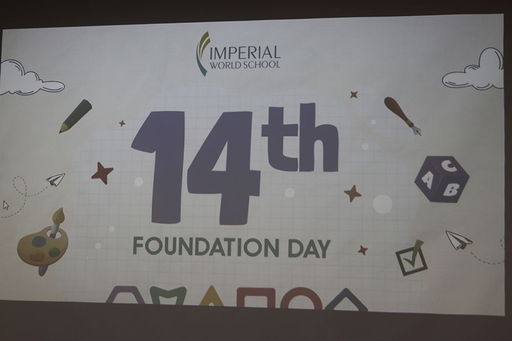 Staff and students celebrating 14th Foundation Day with cake at Imperial World School on 10 May 2024.